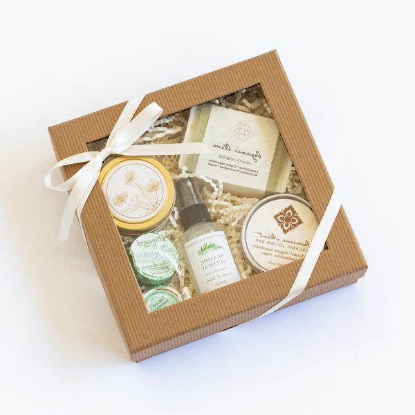 Clear lid gift box with spa essentials and California candle tied with ribbon